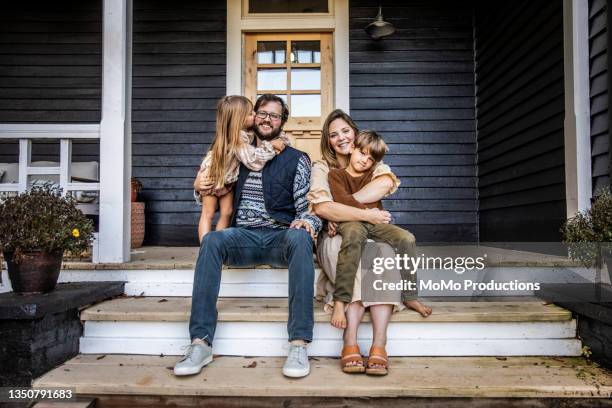 portrait of young family in front of farmhouse - house front bildbanksfoton och bilder