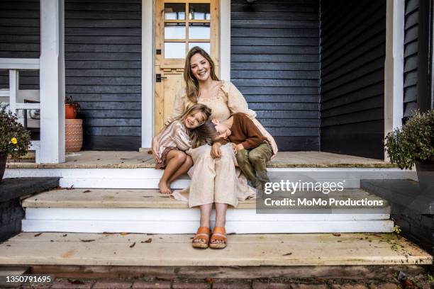 portrait of young mother and children in front of farmhouse - single mother portrait stock pictures, royalty-free photos & images