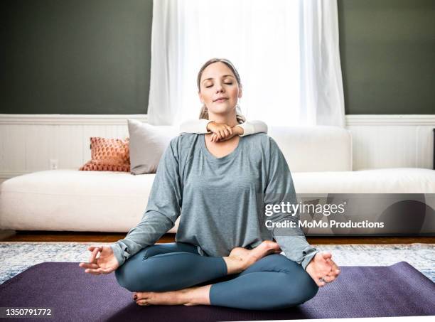 mother and daughter doing yoga at home - yoga kissen stock-fotos und bilder