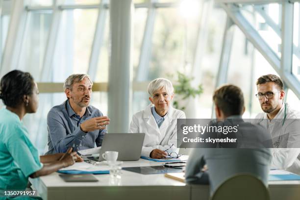 group of doctors and businessmen talking on a meeting at doctor's office. - men meeting stockfoto's en -beelden