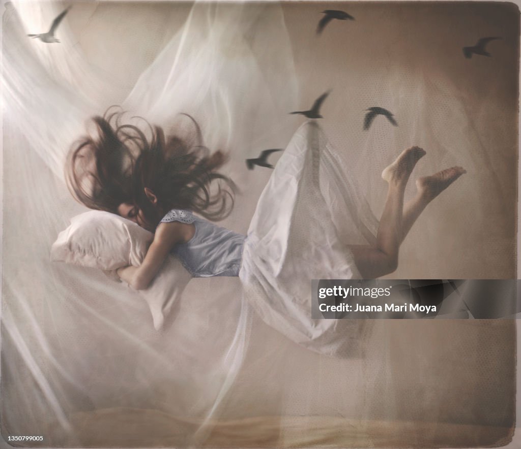 A sleeping woman floats in her room.