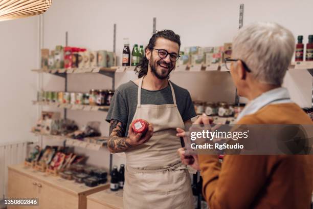 charming young salesman recommending the product to his customer - persuasion stock pictures, royalty-free photos & images