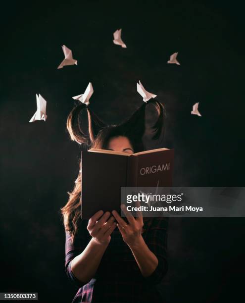 woman reading a book about origami - soul stories stock pictures, royalty-free photos & images