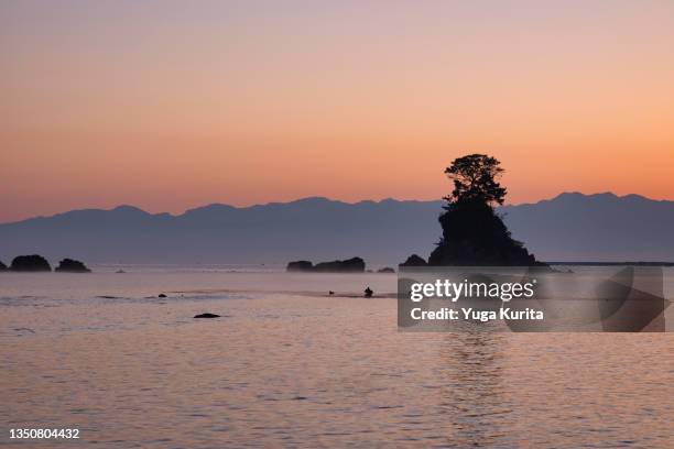 tateyama mountain range over the toyama bay and onnaiwa (meiwa) rock shot from amaharashi coast - toyama prefecture 個照片及圖片檔