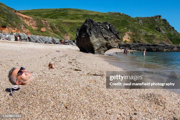 adult male buried at beach - water's edge stock pictures, royalty-free photos & images