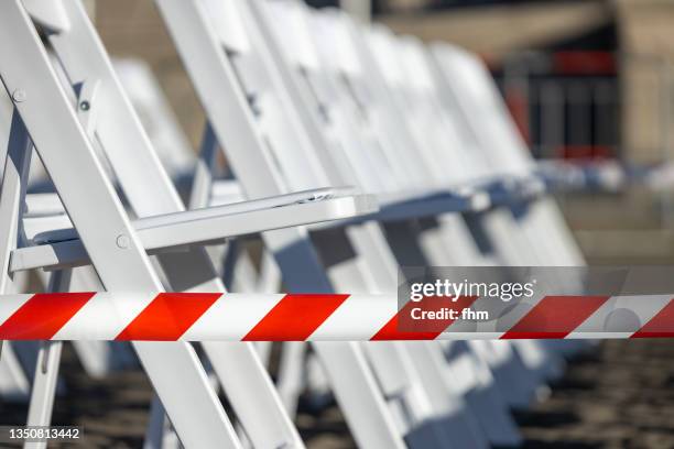 barrier tape and lots of chairs - barrikade stock-fotos und bilder