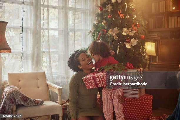 Little girl kissing mom in gratitude for Christmas gift
