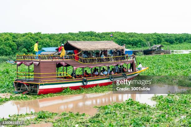 floating village, on tonle sap lake, cambodia. tourist boat. - tonle sap stock pictures, royalty-free photos & images