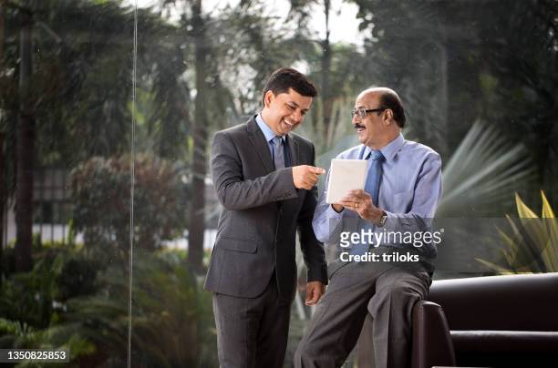 two businessmen discussion at office wile using digital tablet - modern india stock pictures, royalty-free photos & images