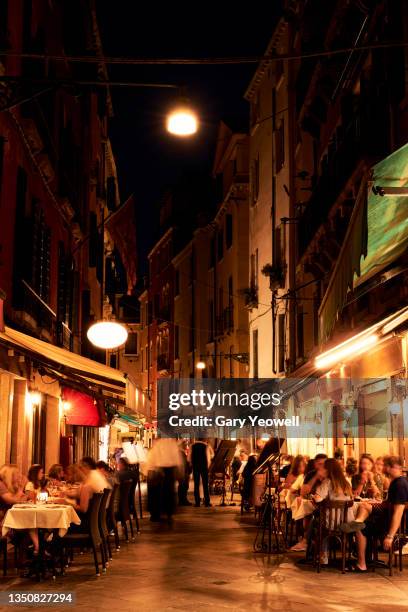 people dining along a cobbled street in venice at night - long exposure restaurant stock pictures, royalty-free photos & images