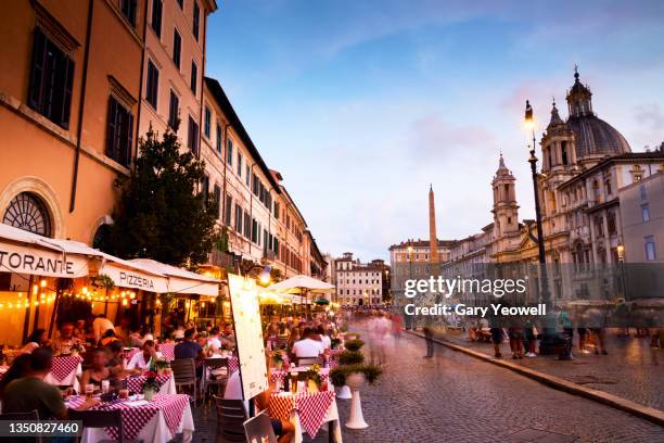 people dining outside in piazza navona in rome at dusk - rome - italy ストックフォトと画像