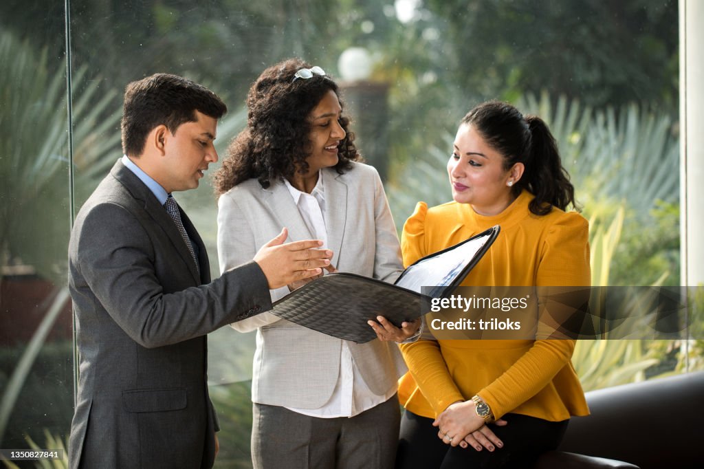 Colleghi di lavoro che discutono sui rapporti archiviati in ufficio