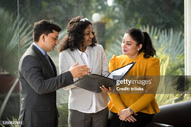 business colleagues discussing over filed reports at office - prime minister of india stockfoto's en -beelden