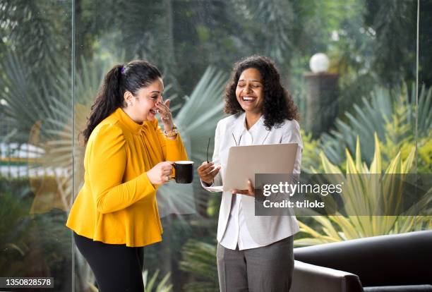 two happy businesswomen discussing at office - coffee meeting with friends stockfoto's en -beelden