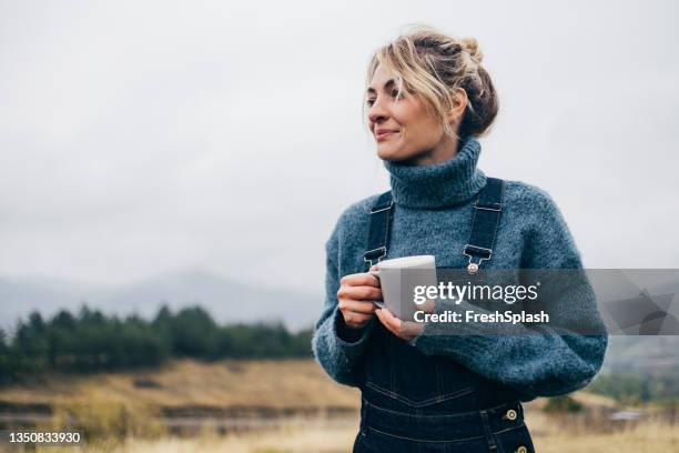 schöne frau, die tee in der natur trinkt - freizeit latzhose stock-fotos und bilder