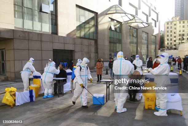 Local residents queue up for COVID-19 nucleic acid testing at a temporary Covid-19 testing site on November 1, 2021 in Xining, Qinghai Province of...