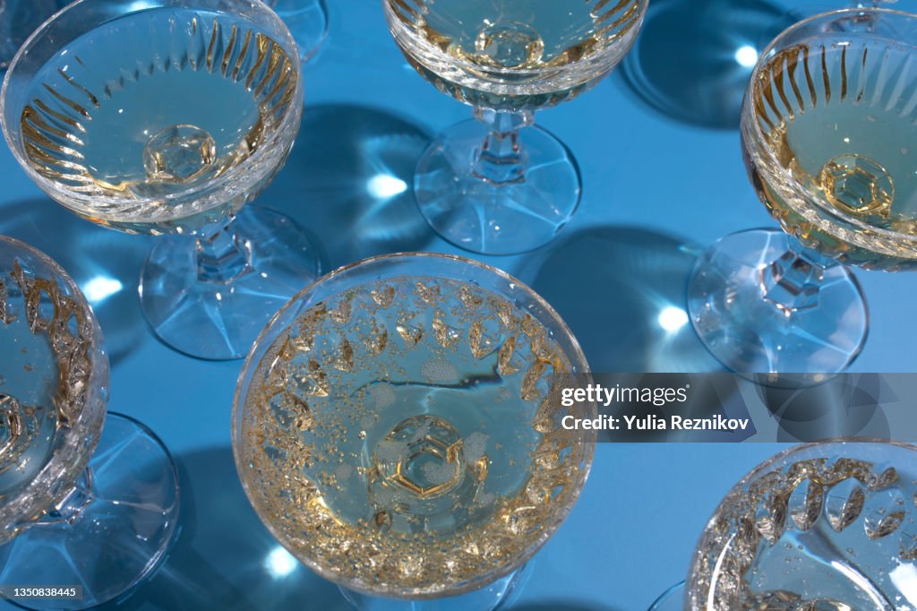 Top view of repeated champagne in glasses on the blue background