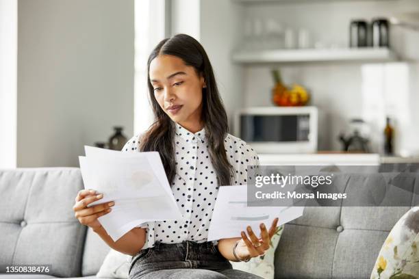 mujer analizando documentos financieros en casa - comparar fotografías e imágenes de stock