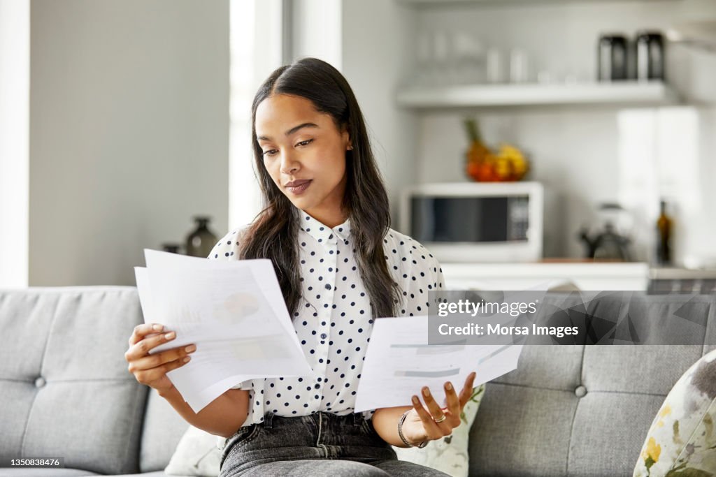 Woman analyzing financial documents at home