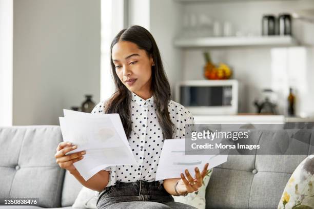 woman analyzing financial documents at home - comprare stock pictures, royalty-free photos & images