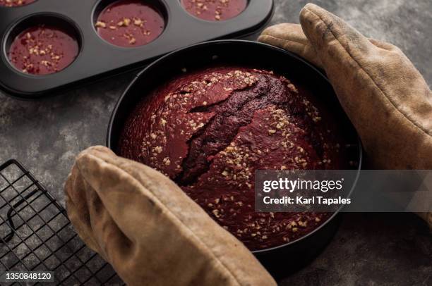 freshly baked red velvet cake taken out from the oven - making cake stockfoto's en -beelden