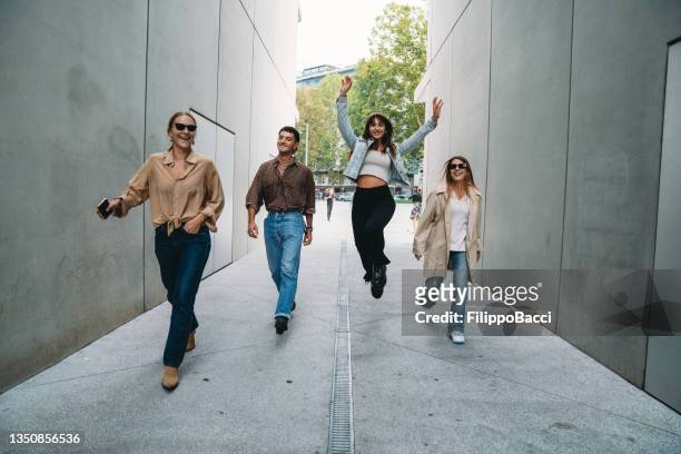 four friends are having fun together outdoor - four people walking stock pictures, royalty-free photos & images