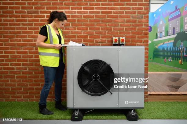 Project engineer checks the paperwork for the installation of a Daikin 7KW heat pump on a model house within the Octopus Energy training facility on...