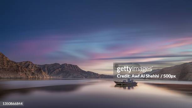 scenic view of lake against sky during sunset,khasab,oman - reading v oman stockfoto's en -beelden