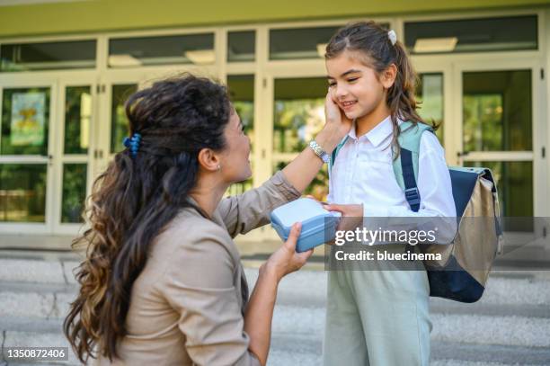 school child taking lunch box from her mother - lunch box stock pictures, royalty-free photos & images