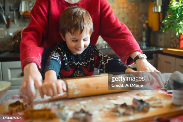 family cooking christmas cookies at the kitchen - rollende keukens stockfoto's en -beelden