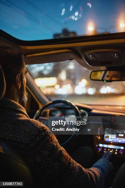 man driving car in the city streets at night - painel de instrumentos imagens e fotografias de stock