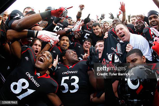 Head Coach Butch Jones of the Cincinnati Bearcats celebrates with his team after the Bearcats defeated the Connecticut Huskies 35-27 to claim their...