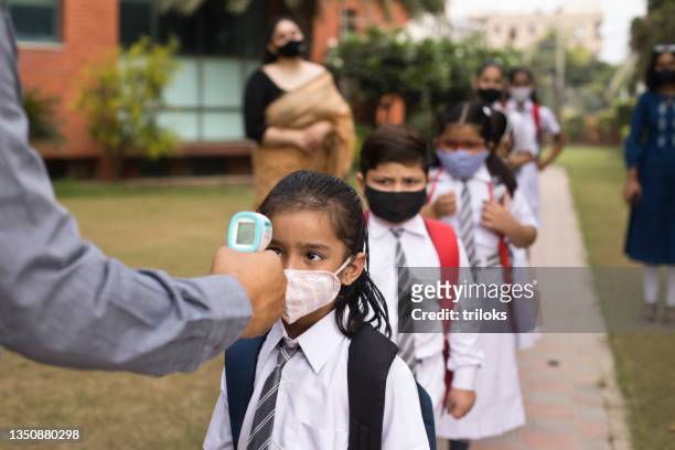 students getting temperature checked before entering school - covid 19 stock pictures, royalty-free photos & images