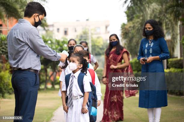 students getting temperature checked before entering school - reopening ceremony stockfoto's en -beelden