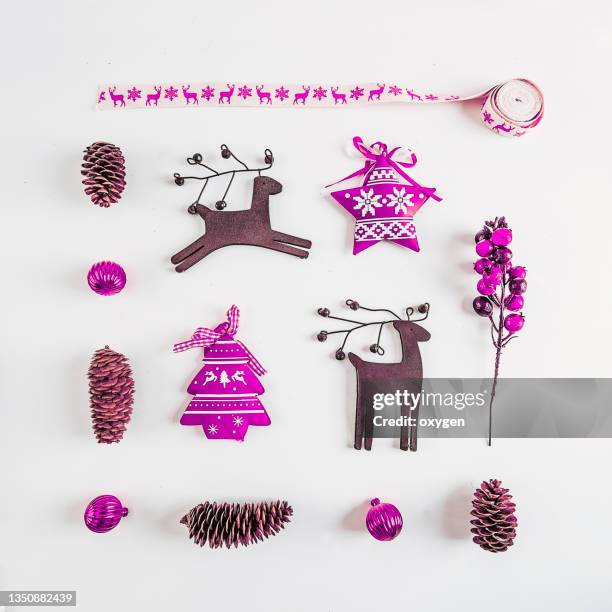 christmas violet background, small scandinavian styled decorations lying on white table. - christmas toys wooden background stockfoto's en -beelden