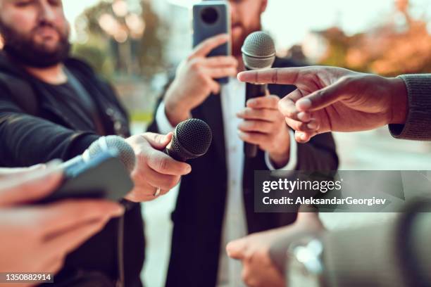 african male pointing while giving statement for journalists outside - media press conference stock pictures, royalty-free photos & images