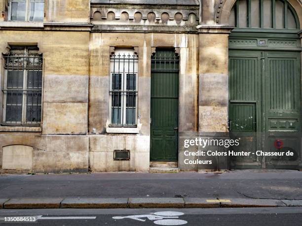 old stone building facade with doors and empty street in paris - bulevar - fotografias e filmes do acervo