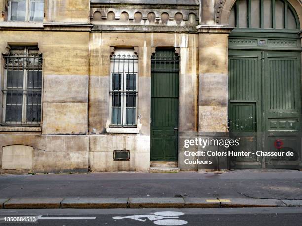 old stone building facade with doors and empty street in paris - boulevard bildbanksfoton och bilder