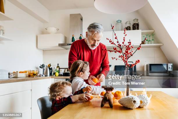 grandchildren having a snack while spending time with grandfather - red shirt stock pictures, royalty-free photos & images