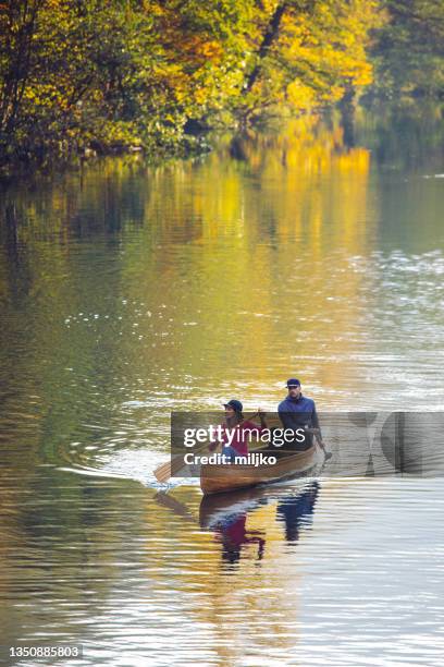 couple profitant d’une merveilleuse journée en canoë sur la rivière - bateau à rames photos et images de collection