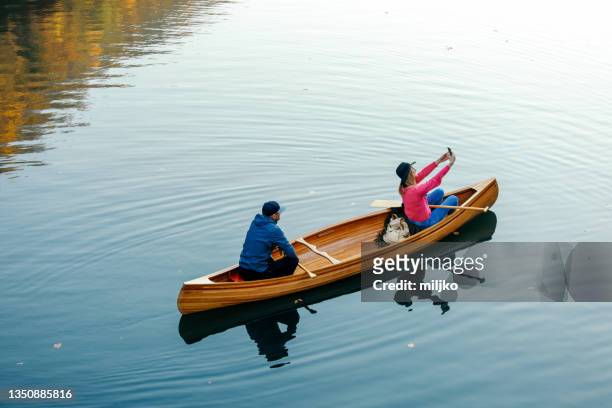 couple enjoying wonderful day in canoe on river - canoeing stock pictures, royalty-free photos & images