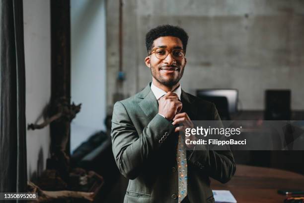 111 Young Black Business Man In A Suit And Fixing His Tie Photos and  Premium High Res Pictures - Getty Images