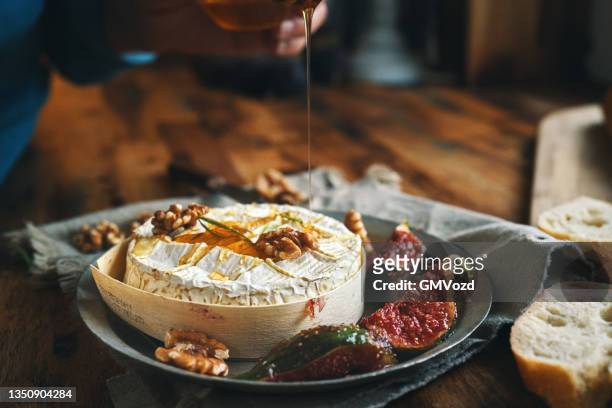 baked camembert cheese served with honey and fresh figs - camambert bildbanksfoton och bilder