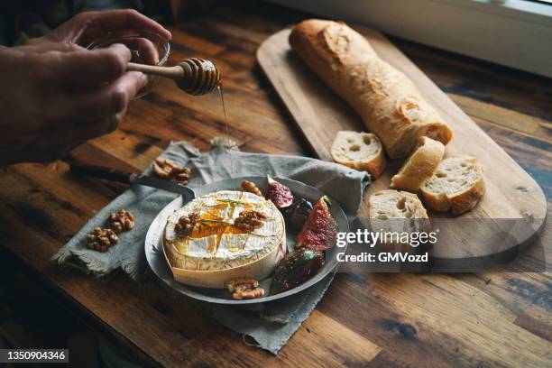 gebackener camembert-käse serviert mit honig und frischen feigen - french cheese shop stock-fotos und bilder