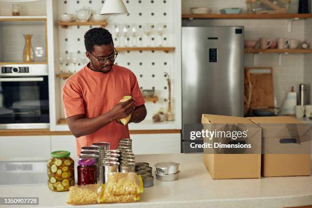 young black man donating food to charity - basic food stock pictures, royalty-free photos & images