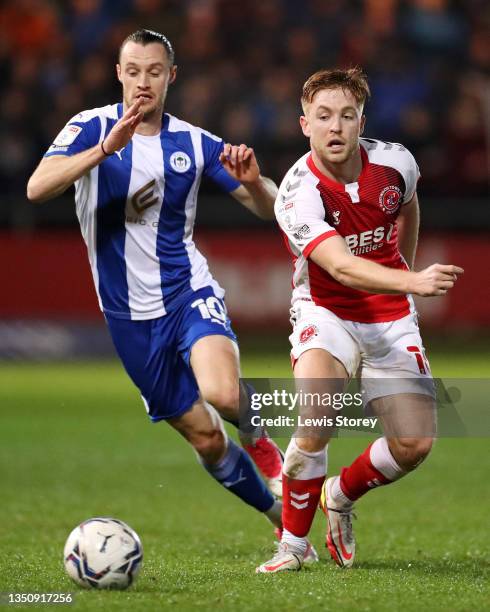 Callum Camps of Fleetwood Town makes a pass whilst under pressure from Will Keane of Wigan Athletic during the Sky Bet League One match between...