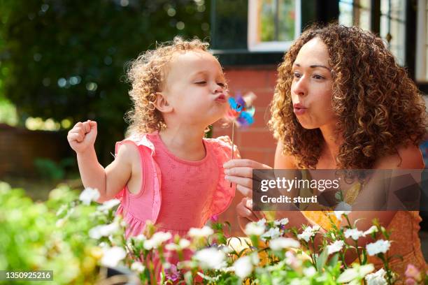 mother and daughter with toy windmill - paper windmill stock pictures, royalty-free photos & images