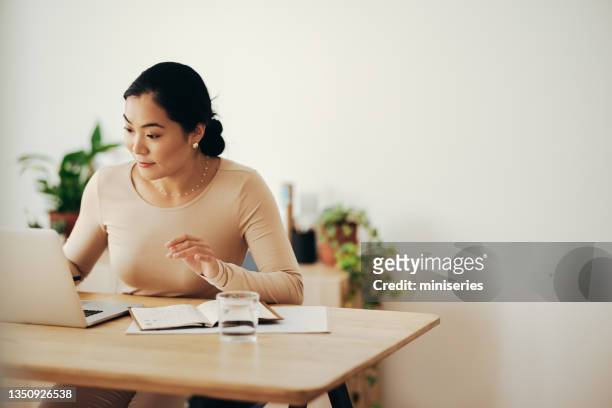 glückliche geschäftsfrau, die von zu hause aus auf einem laptop arbeitet - finanzbericht stock-fotos und bilder