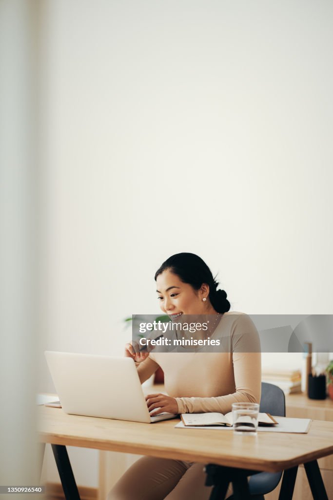 Happy Business Woman Working from Home on Laptop Computer