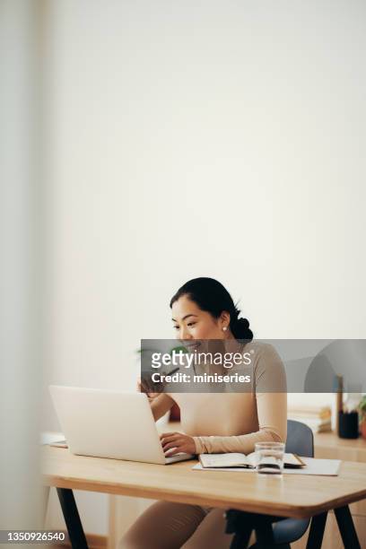 happy business woman working from home on laptop computer - mongolian women 個照片及圖片檔